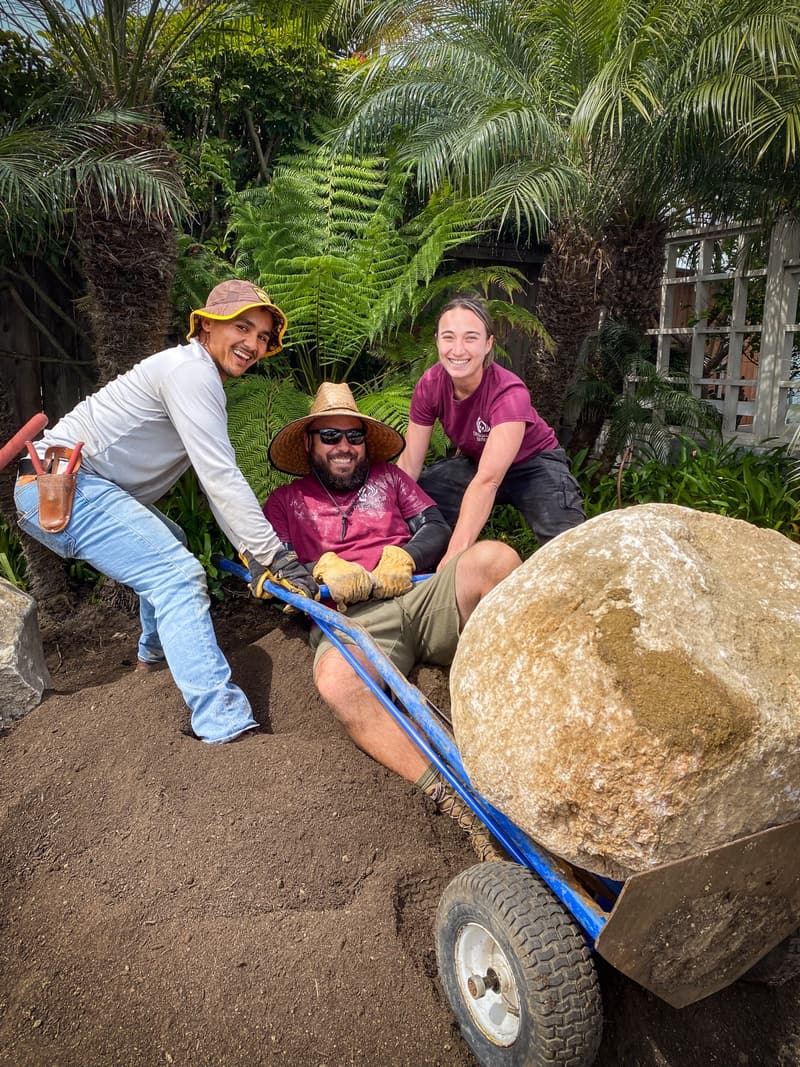 Three Design for Serenity crew members wheeling a boulder on a hand truck